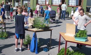Unger og voksne rundte bordene hvor elevene selger blomster
