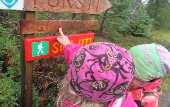 Barn som peikar på turskilt i Aukraskogen