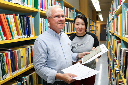 Bibliotekar Edvard Johan Strand sammen med sin funksjonsassistent Lin Jia inne på NH-biblioteket, Universitetsbiblioteket i Tromsø.