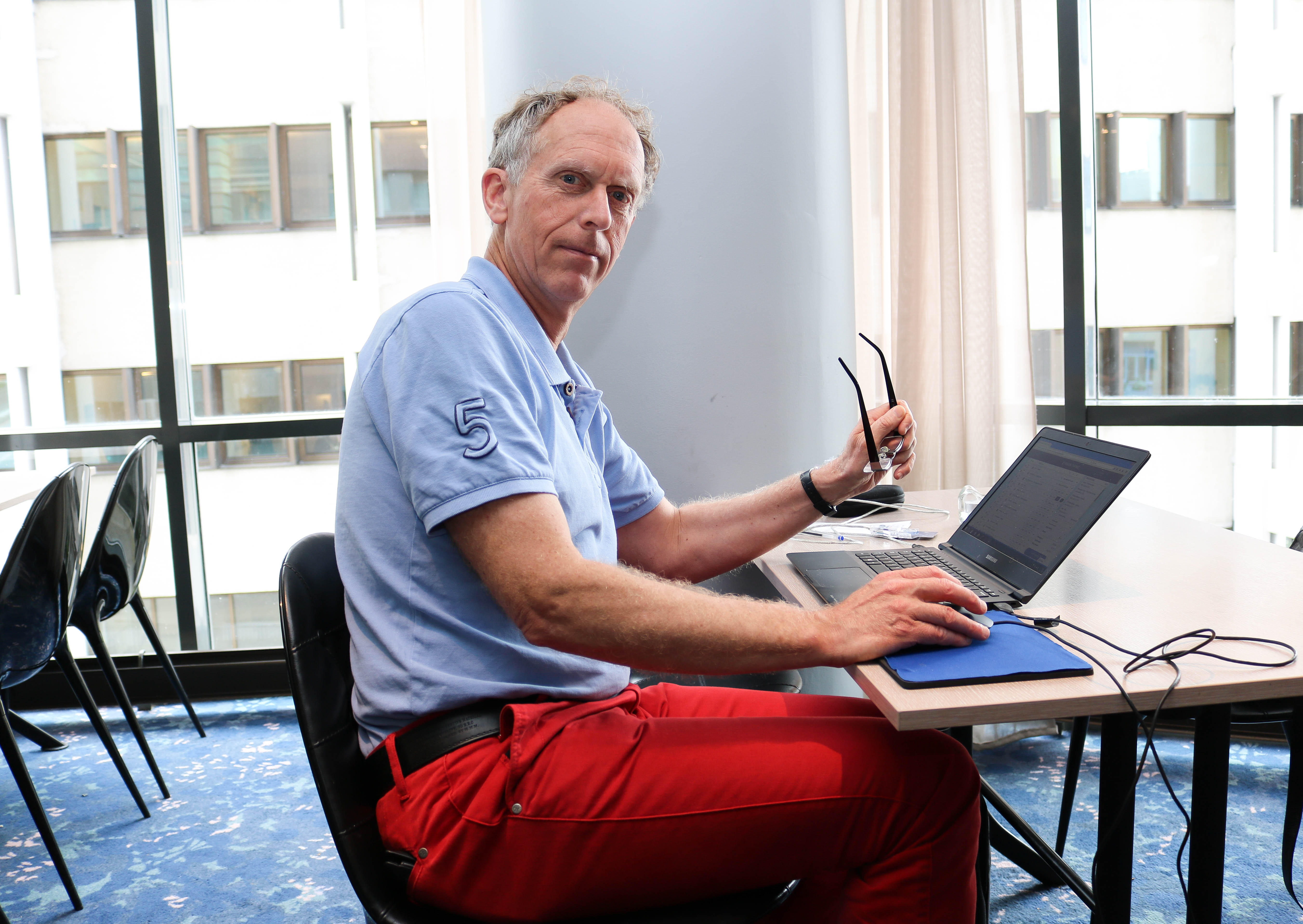 En mannlig FNDB-deltaker sitter med sin laptop i en pause. 