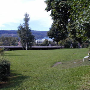 Park, plen med hvit benk, Fåberggata i bakgrunnen