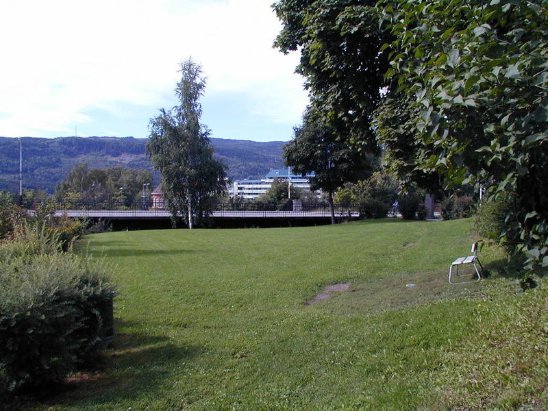 Park, plen med hvit benk, Fåberggata i bakgrunnen