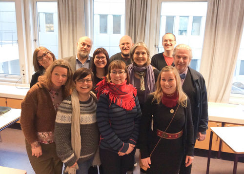 Helst fremst til høyre, rådgiver Bodil Ballovara Olufsen. Foto: Elena Hauge. Gruppebilde av elleve smilende personer, stående foran en rekke med avlange vinduer, i et undervisningsrom. Sju av dem er kvinner, mens resten er menn.