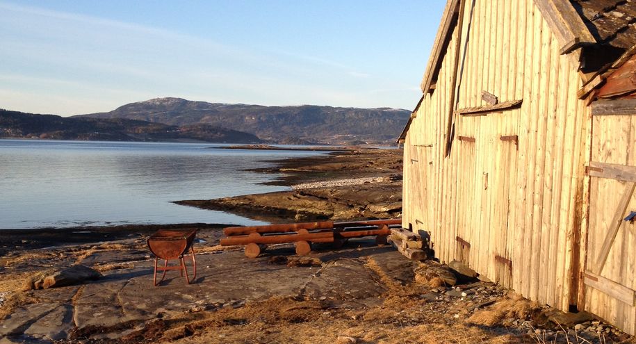 Bilde fra Flatholman friluftsområde med naust i sjøkanten