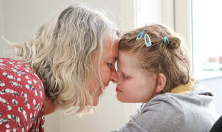 Nært: Alma Skredlund sammen med sin mor Elisabeth. Foto: Roy-Morten Østerbøl. Mor og datter helt tett, panne mot panne. De smiler, datter har øynene igjen.