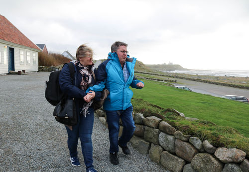 Kjetil Opsanger ledsages av Olaug Grude Hobberstad utenfor Hå gamle prestegård. Foto: Roy-Morten Østerbøl. Kvinne ledsager mann med CHARGE-syndrom ved et steingjerde, utenfor Hå gamle prestegård på Jæren.