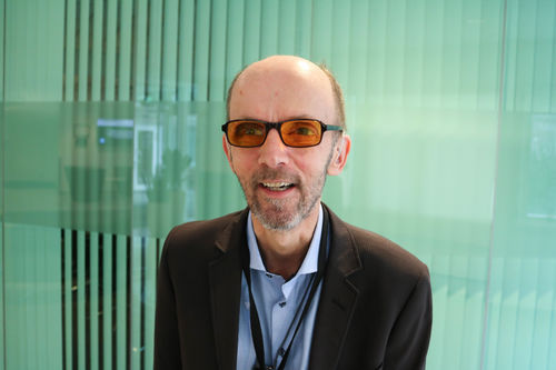 Foto: Roy-Morten Østerbøl. Glad mann med oransje filterbriller, lysegrønn og lett gjennomsiktig bakgrunn.