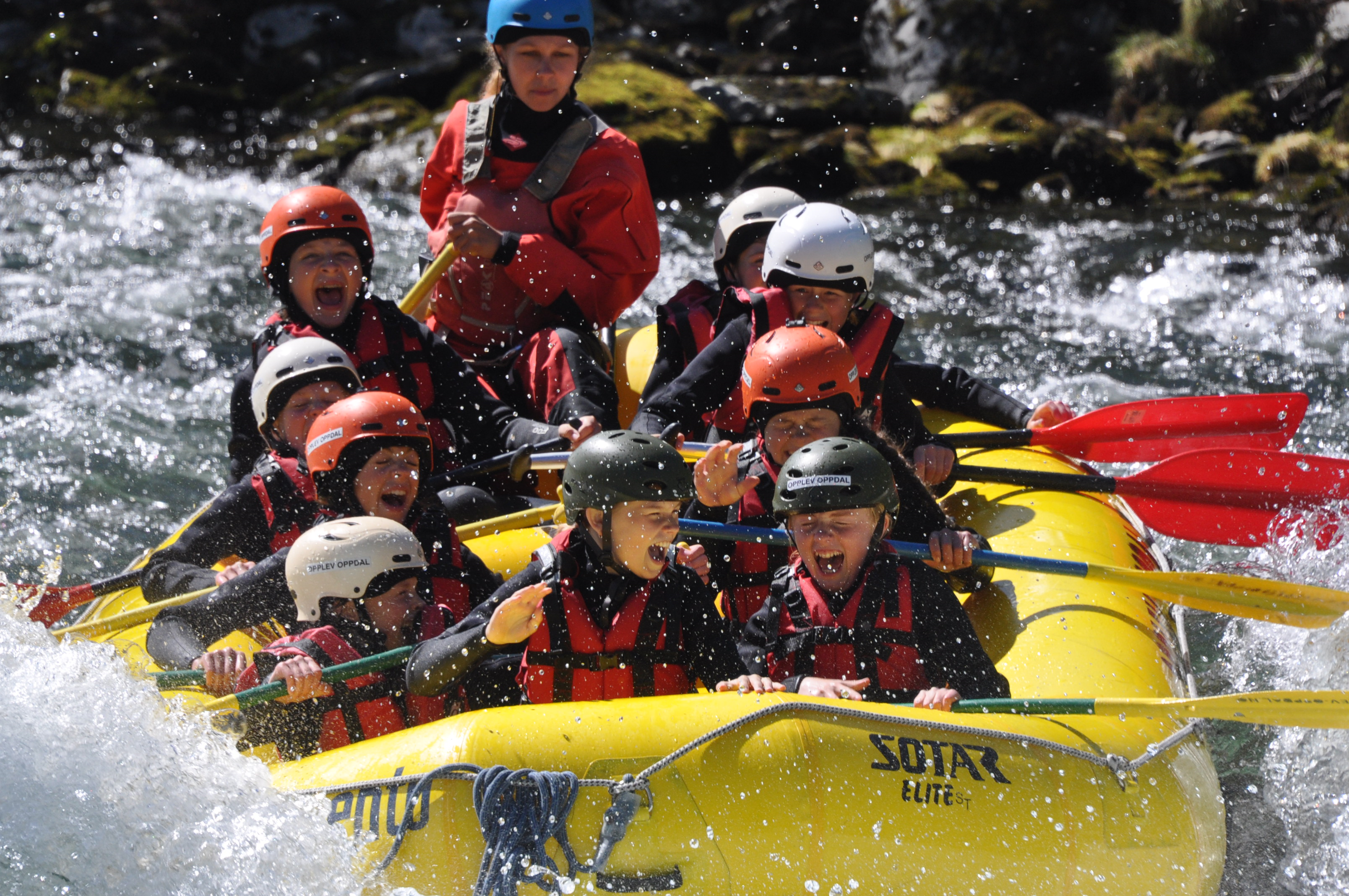 En gruppe mennesker i en raftingbåt i en elv.