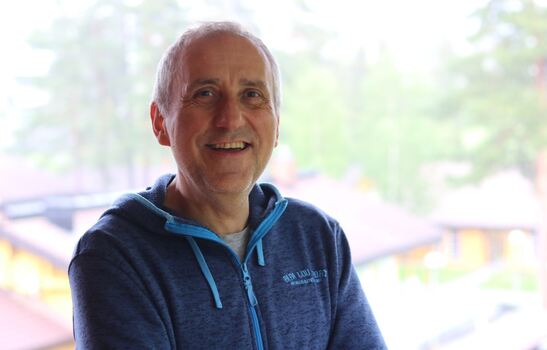 Smilende herre med mørkeblå hettegenser.