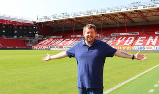 Christian Jensen inne på flotte Brann stadion. Foto: Roy-Morten Østerbøl. Mann i blå piquet poserer inne på Brann stadion i Bergen.