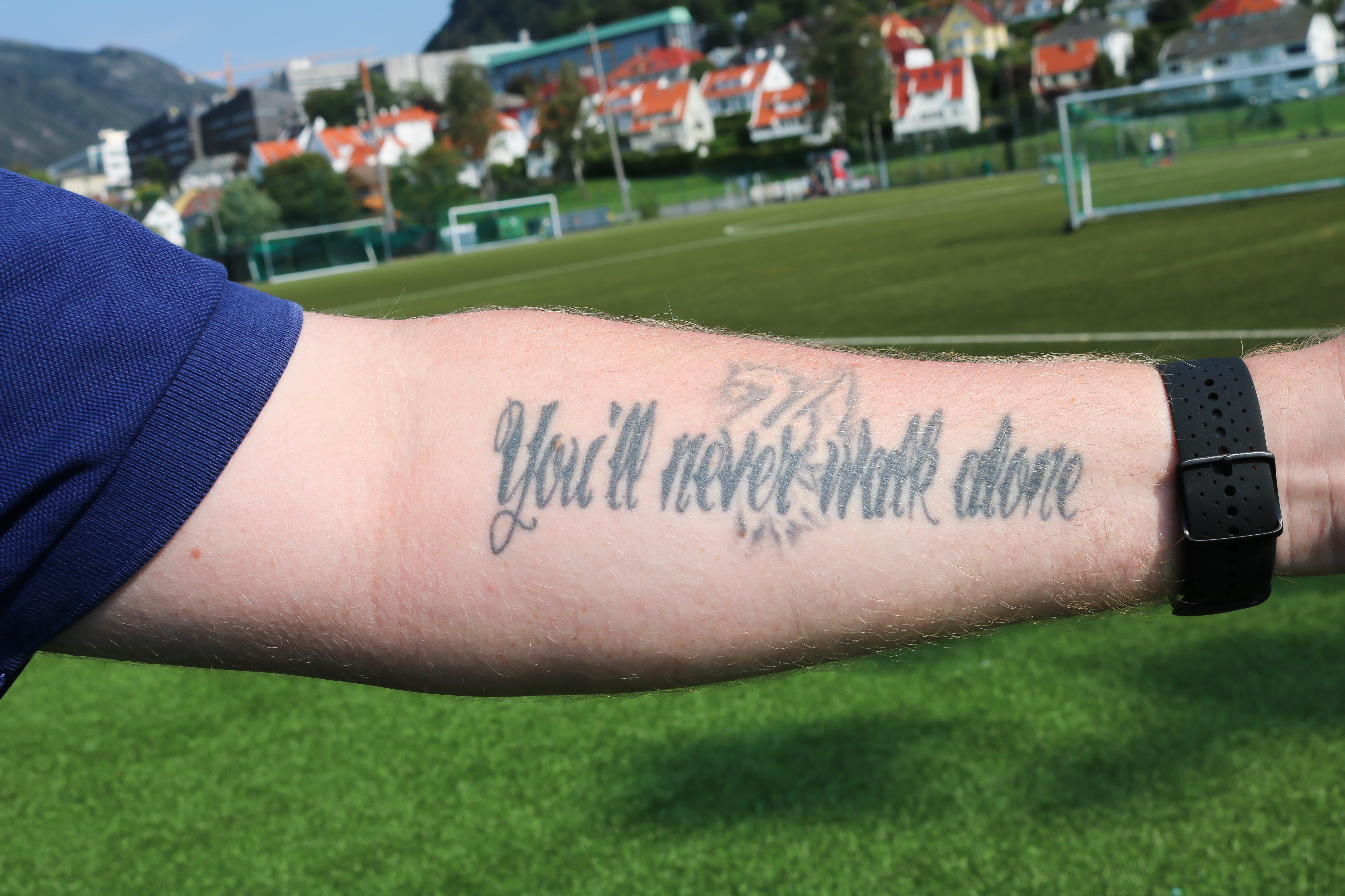 Venstre underarm med tatoveringen: You’ll Never Walk Alone.. 