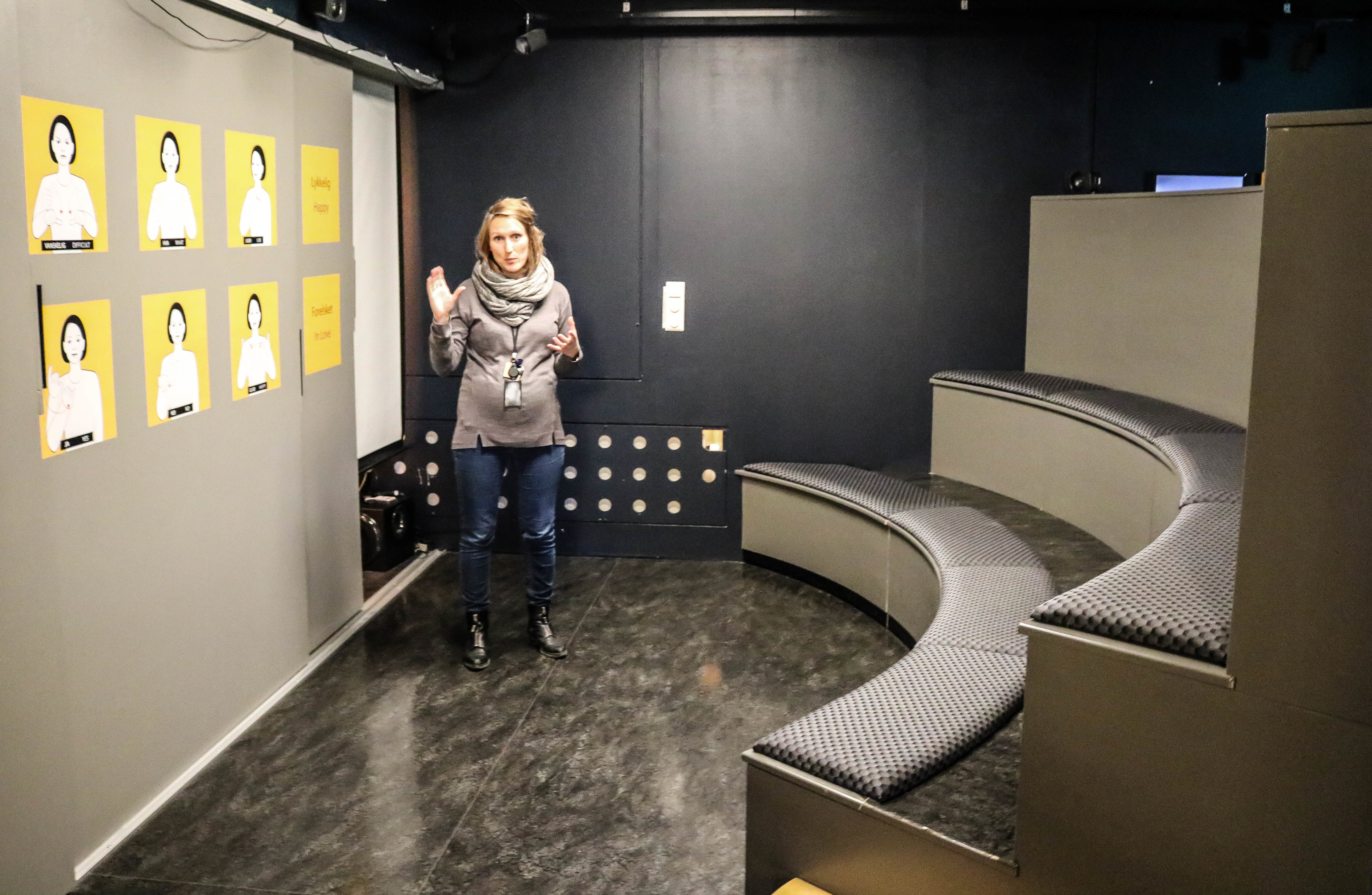 Kvinne viser fram formidlingsrom på Norsk døvemuseum. 