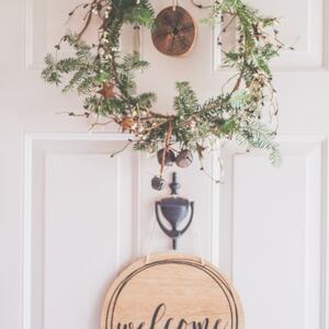photo-of-a-white-door-with-a-hanging-wreath-and-welcome-1652394