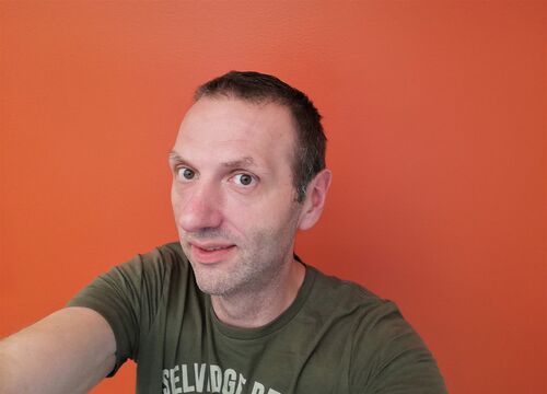 Foto: Privat. Mann tar selfi med oransje bakgrunnsvegg.