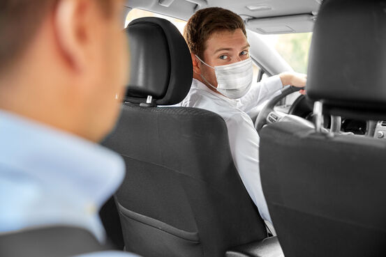 37227399-taxi-driver-in-face-protective-mask-driving-car