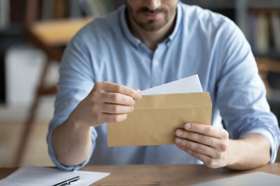 37652355-focused-businessman-reading-letter-holding-envelope-in