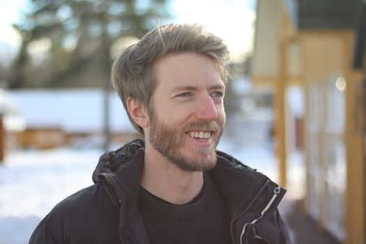 Portrettbilde av smilende mann, vinter-bakgrunn.