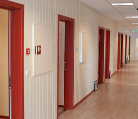 Mange røde dører i god kontrast til hvit vegg.