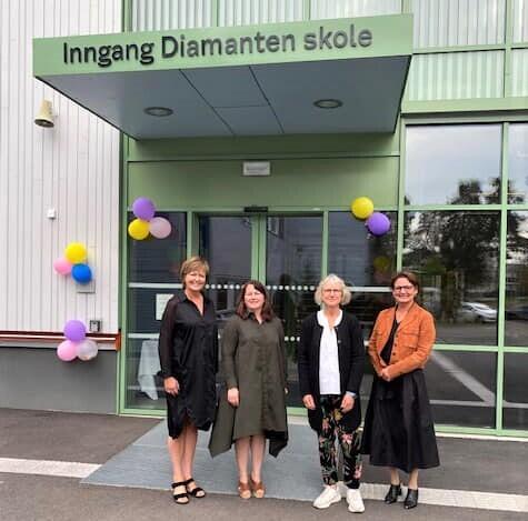 Fra venstre: Elisabet Dahle, Hege Kristine Høgmo, Marianne Disch og Annemarie Bechmann Hansen. Foto av Gro Hallan Tønsberg. Fire kvinner står ved inngangspartiet til en flunkende ny skole