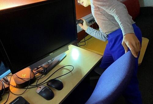 Hvor har de gjemt bamsene? En gutt leter med lykt bak en PC. Foto: Randi Thelle. Gutt lyser med lommelykt bak PC-skjerm.