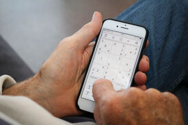 Roy-Morten Østerbøl Eldre mann holder på med sudoko på mobilen sin, en iPhone.
