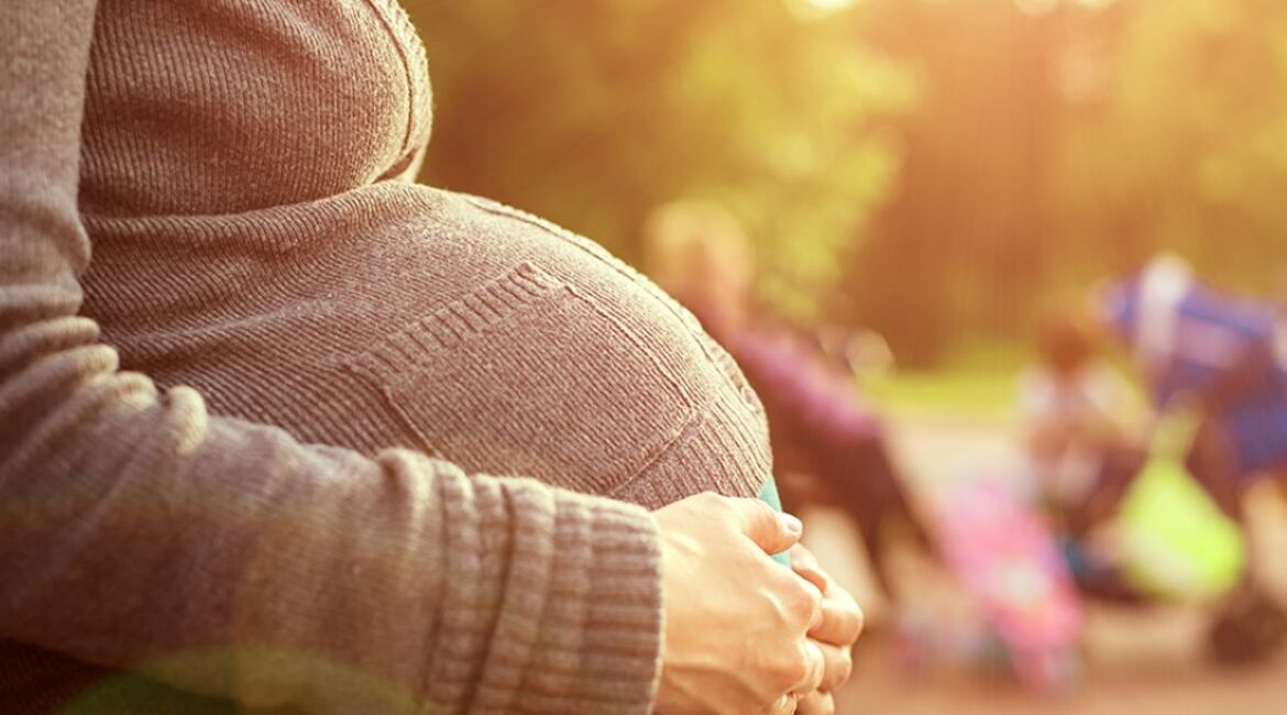 Pregnant woman holding her hands over her belly