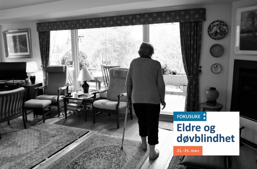 Eldre kvinne med krykke i sitt eget hjem. Sort-hvitt. Fokusukelogo nede til høyre. Eldre og døvblindhet.