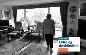 Eldre kvinne med krykke i sitt eget hjem. Sort-hvitt. Fokusukelogo nede til høyre. Eldre og døvblindhet.