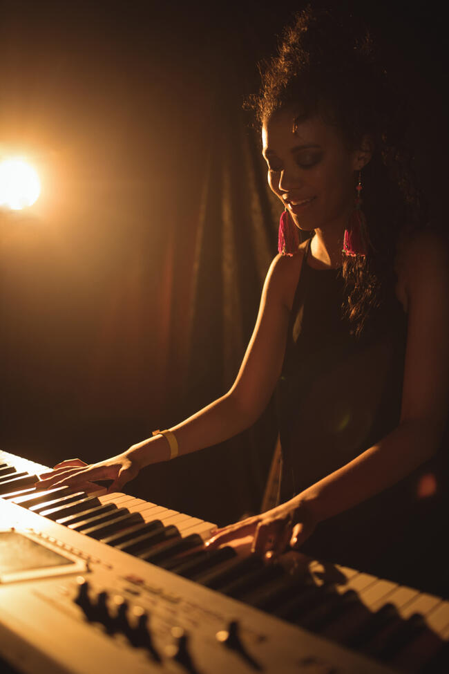 25098687-female-musician-playing-piano-at-music-concert