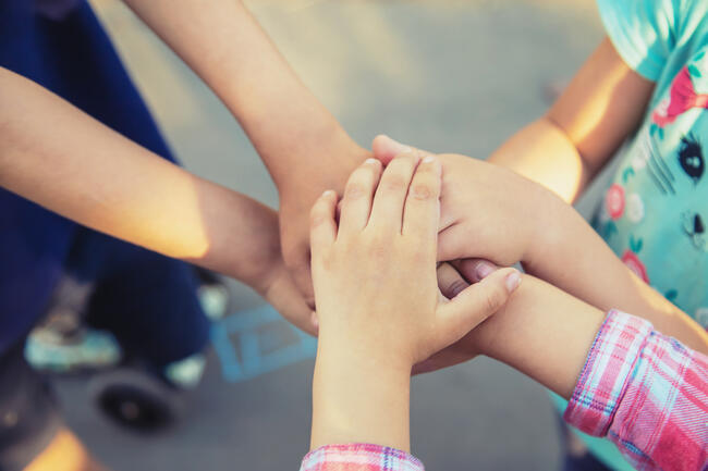 56129679-hands-of-children-many-friends-games-selective-focus