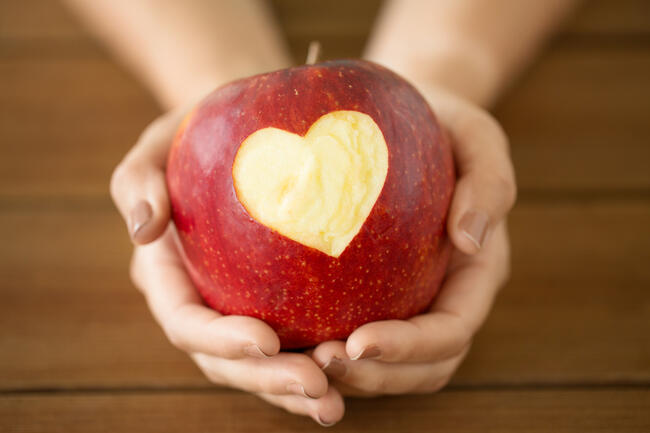 32363596-close-up-of-hands-holding-apple-with-carved-heart