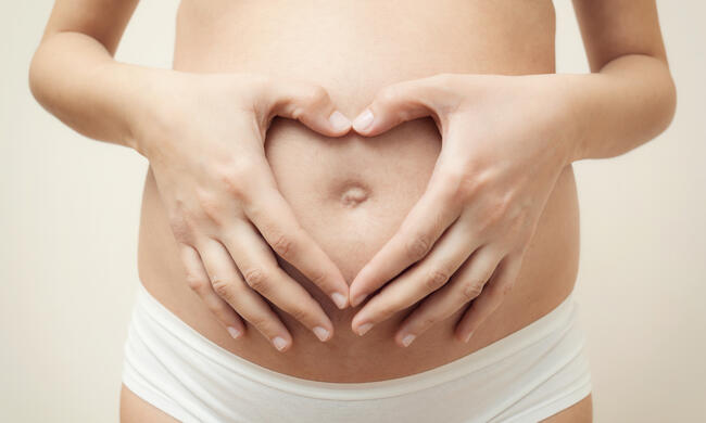 15589714-heart-shaped-hands-of-pregnant-woman-on-her-belly