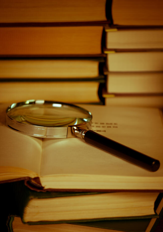 2441219-books-with-magnifying-glass