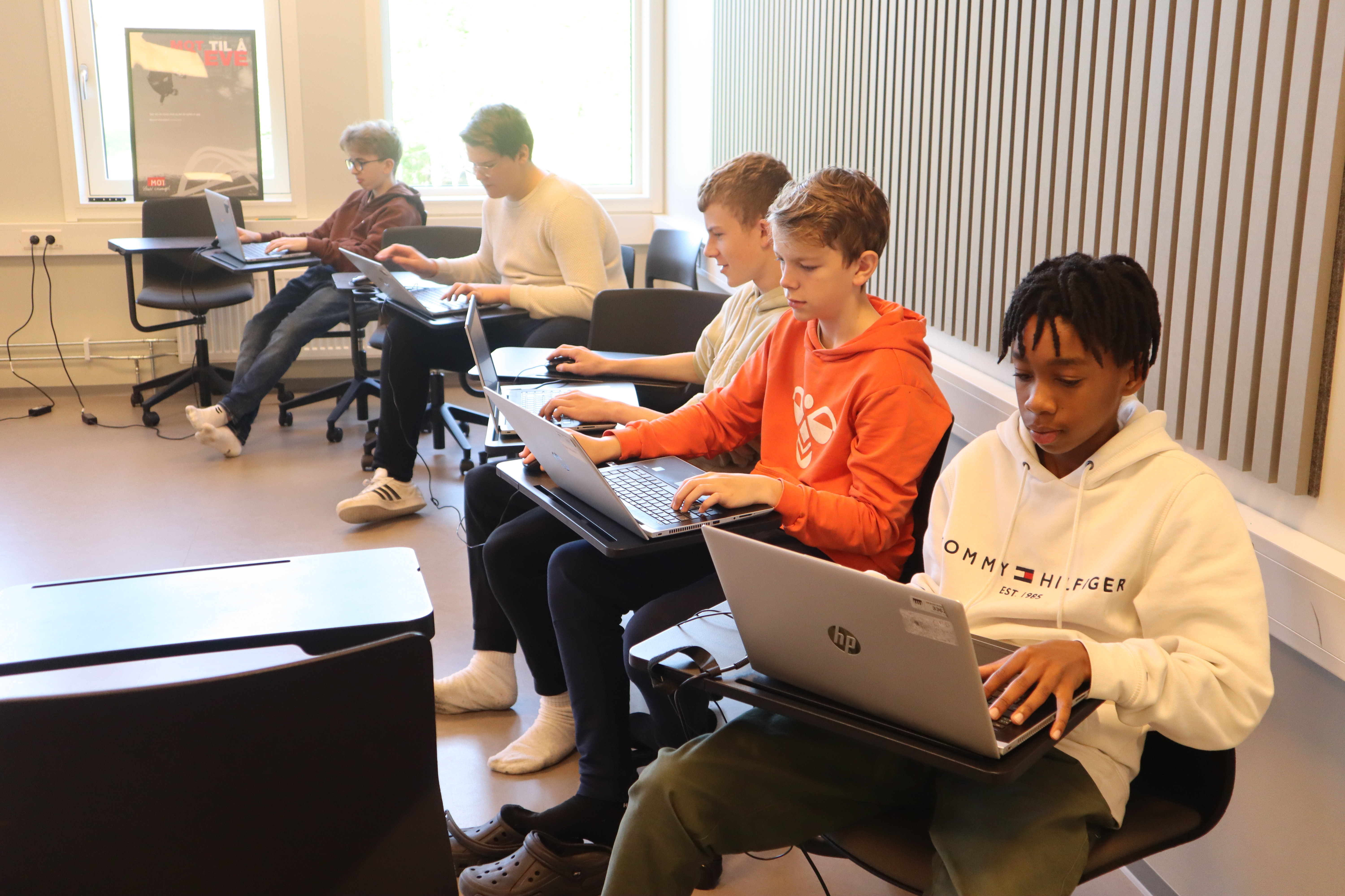 Bilde av fem elever med hver sin laptop.