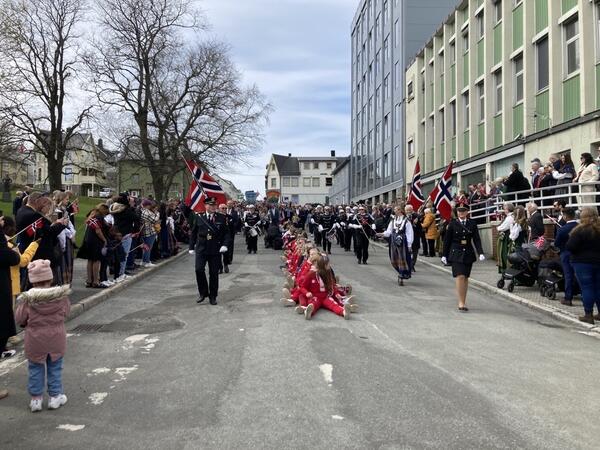 folketog med politi, korps og rødruss i sentrumsgatene i Sandnessjøen.