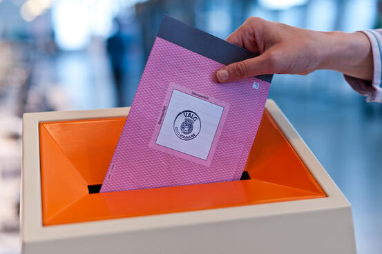 En stemmeseddel som er i ferd med å bli puttet i en urne