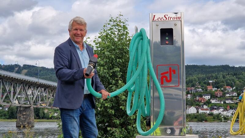 En mann, fungerende ordfører Terje Rønning, holder en slange til tømmestasjon for båter.