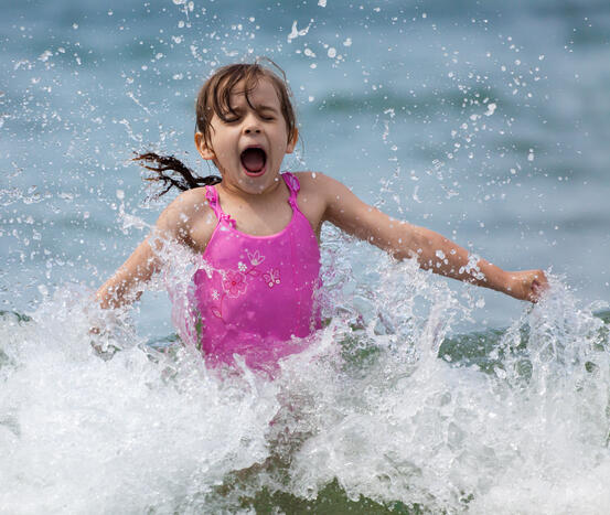 3600316-little-girl-laughing-and-crying-in-the-spray-of-waves