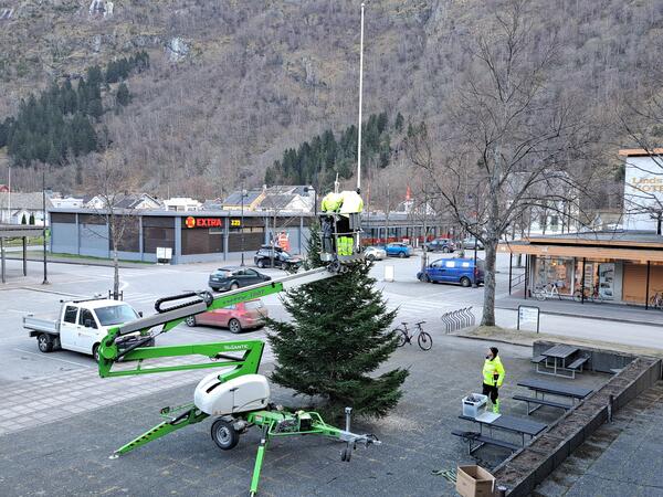 Stjerna blir løfta på plass i toppen av julegrana