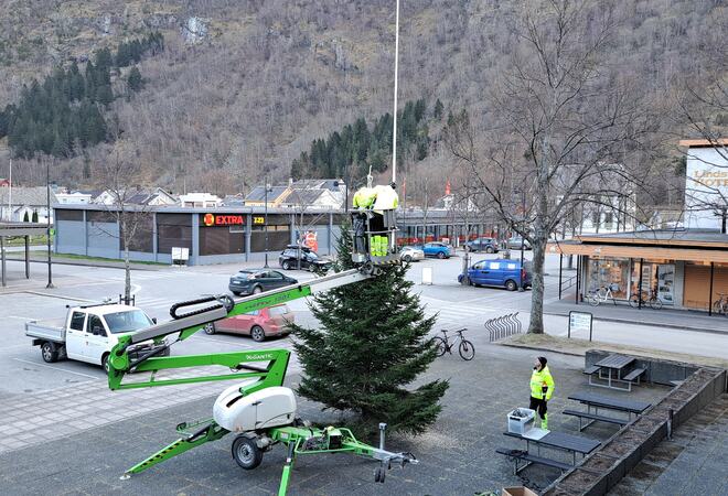 Stjerna blir løfta på plass i toppen av julegrana