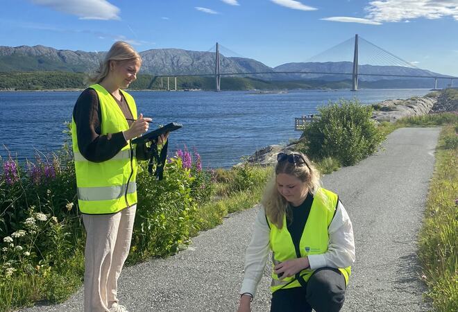Eline Lie og Lena Lie Andersen måler tverrfall og helningsgrad på adkomstveien ned mot fiskeplassen ved Vindenes hus.