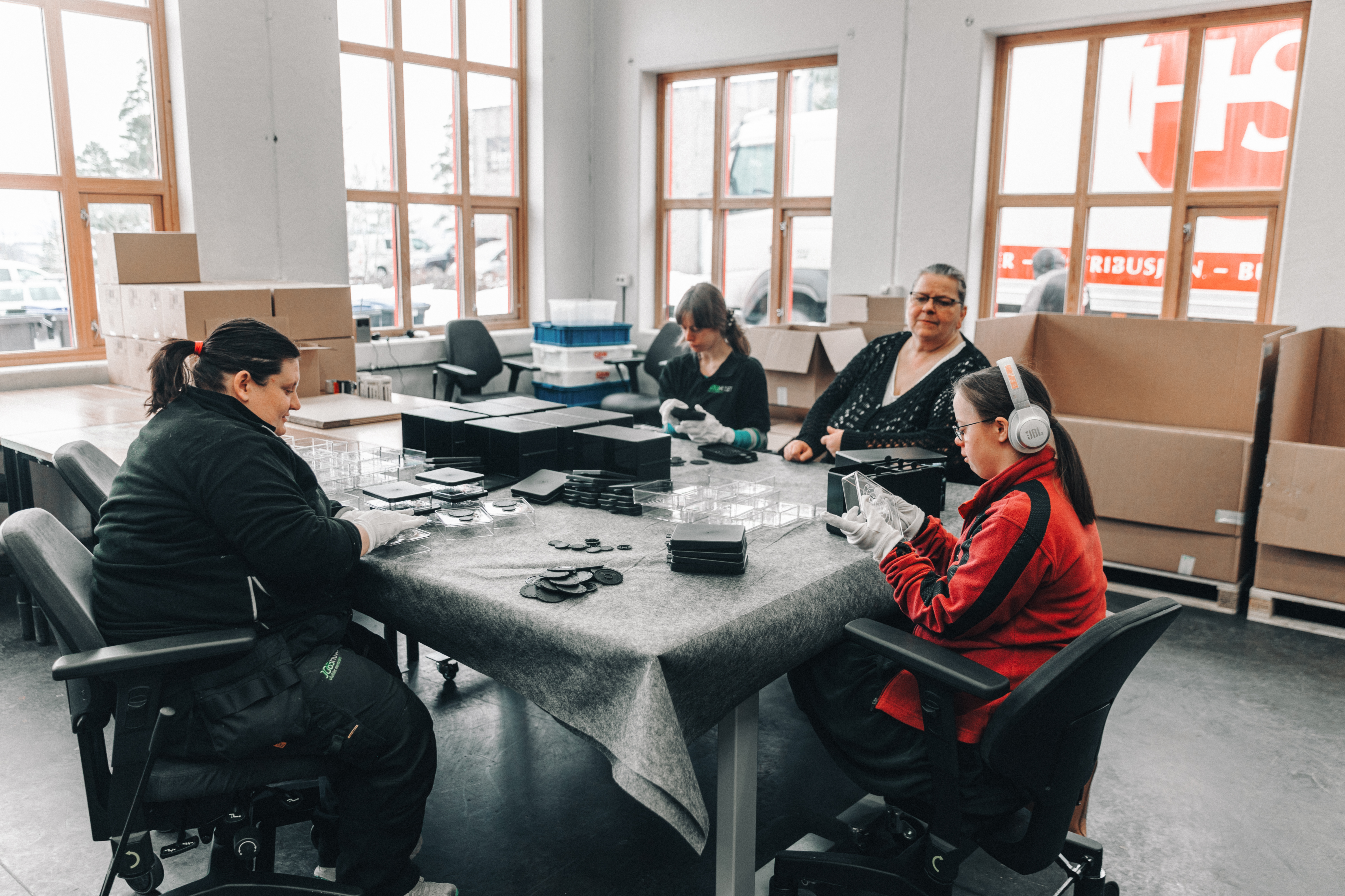 Personer sitter rundt et bord og lager produkter