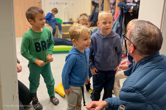 Kommunalsjef Stian Høyen hilser på barna i Nordvågen barnehage.