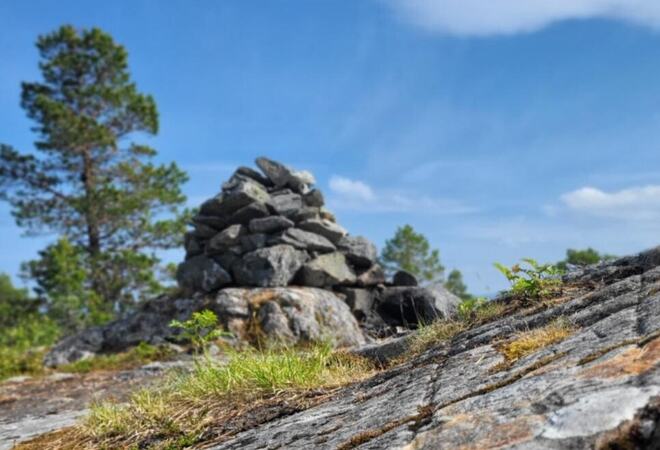 Foto: Britt Monika Grostad En varde på en fjellknaus mot blå himmel